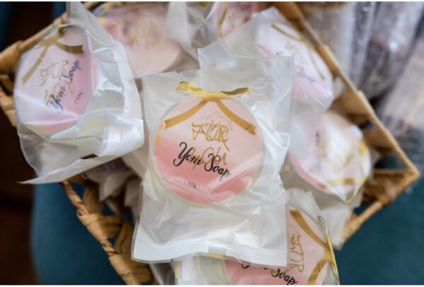 A basket of pink and white cookies with gold bow.