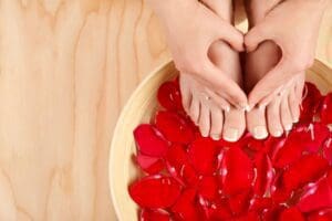 hands in the shape of a heart on top of the feet