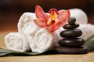 stacked pebbles with a flower on top of three rolled towels
