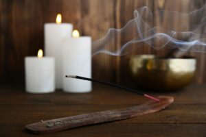 incense with lit candles in the background