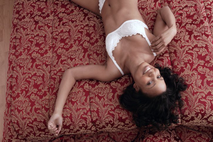 A woman laying on the bed in her underwear