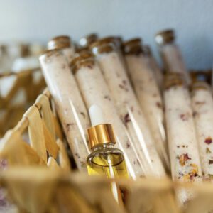 A basket of rolled up white candles with one bottle in the middle.