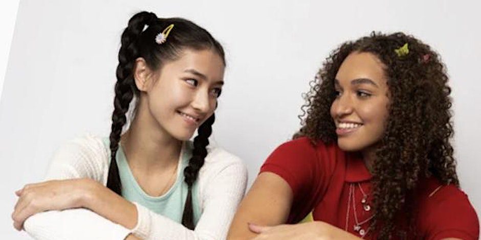 Two young women sitting next to each other.