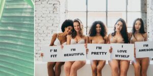 A group of women holding signs that say " i 'm fit beautiful pretty ".