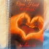 A spiral bound book with the cover of the open heart journal.