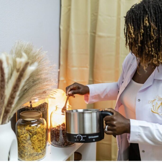 A woman holding a pot with food inside of it.